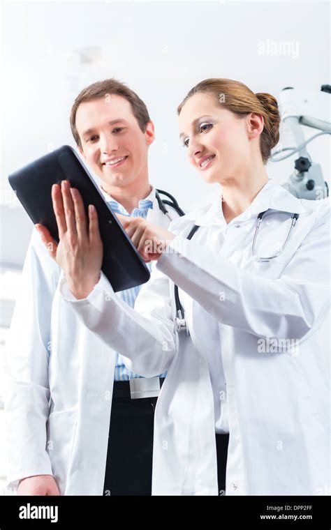 Doctors Male And Female Discussing Test Reports That Show On Their