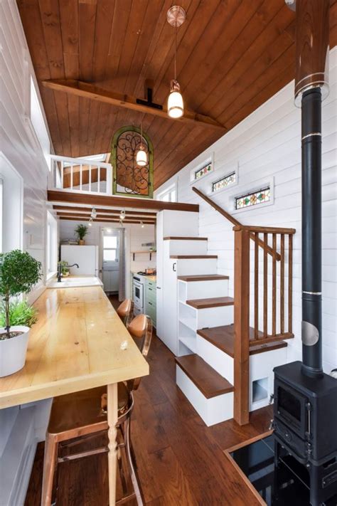 The ceiling was opened up in the main space, but the bathroom and bedroom have lower ceilings to accommodate the parent's sleeping loft above, accessible by a walnut ladder. Beautiful 30' Mint Tiny Home on Wheels with Vaulted Ceilings!