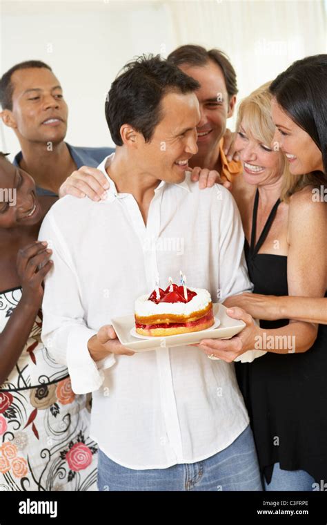 Friends Surprising Man With Birthday Cake Stock Photo Alamy