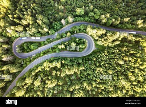 Aerial View Of Winding Road In High Mountain Pass Trough Dense Green