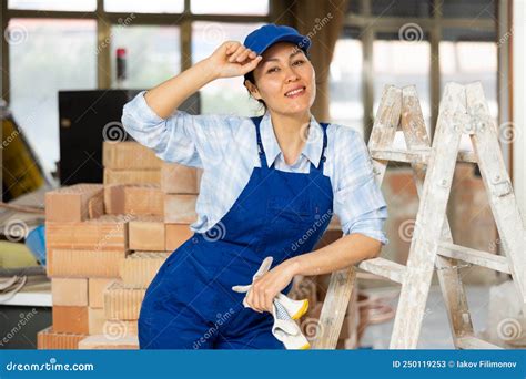 Portrait Of A Woman Builder Posing Near A Stepladder Stock Image