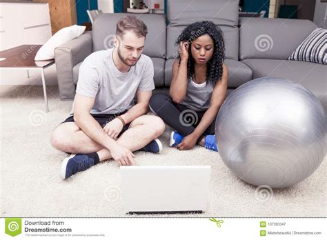 Young Couple Prepares Gymnastic Exercises On The Computer Stock Image