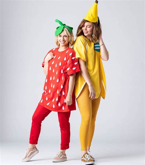 Two Women Dressed In Costumes Standing Next To Each Other One Wearing