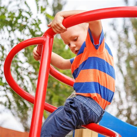 Cute Little Boy Playing On The Playground In The Summer Stock Image