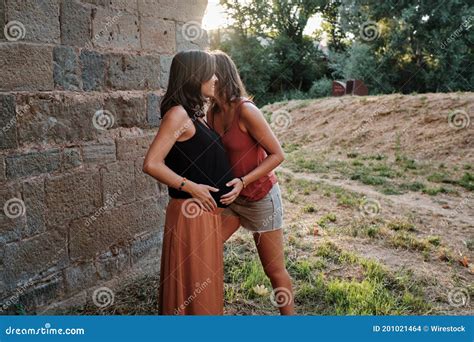 Closeup Of A Pregnant Lesbian Couple Doing A Photoshoot In A Park Stock