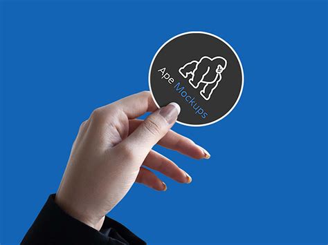 Selamat malam kali ini kami akan berbagi sebuah desain stik. Hand Holding a Sticker PSD Mockup (Free) by Design Bolts
