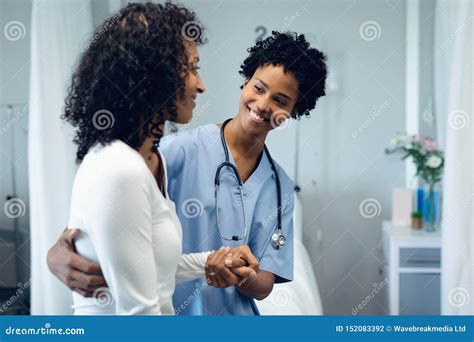 Female Doctor Helping Female Patient To Walk In The Ward At Hospital
