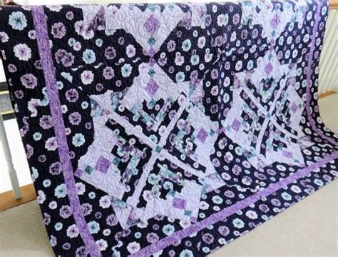 A Black And Purple Quilt With Flowers On It