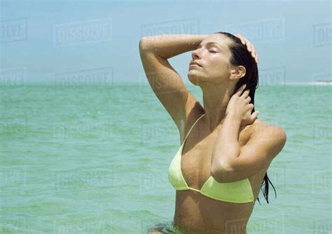 Woman Standing In Sea Eyes Closed And Hands In Hair Stock Photo Dissolve