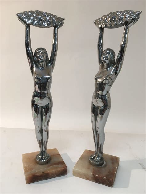 A Pair Of Art Deco Chrome Ornaments Of Nude Female Figures Holding