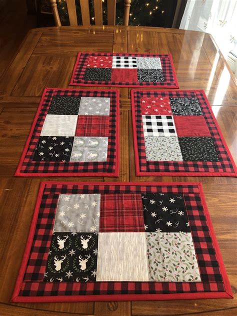 Three Quilted Placemats Sitting On Top Of A Wooden Table Next To A