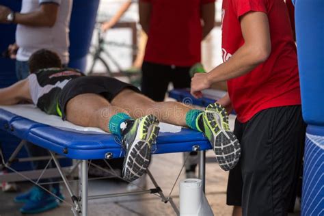 Athlete Lying On A Bed While Having Legs Massaged After A Physical