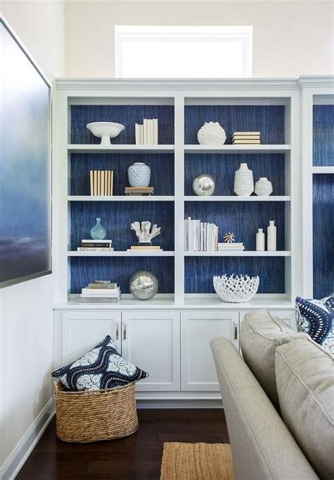 Blue Wallpaper Behind A White Bookcase Giving A Stunning Contrast To A