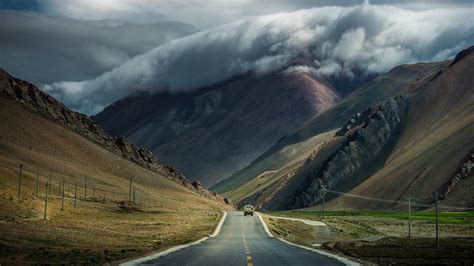 Black Road Between Brown Mountain Road Mountains Clouds Hd Wallpaper