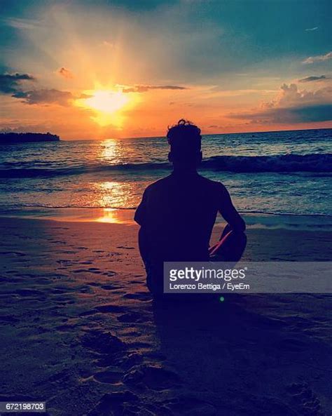 Men Sitting Alone On The Beach Silhouette Photos And Premium High Res