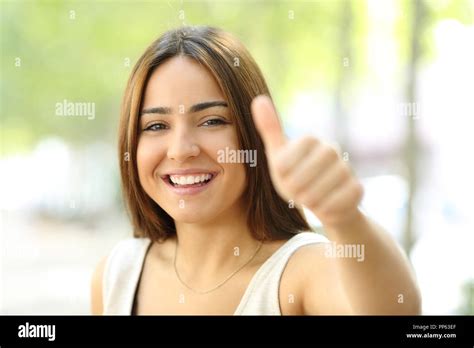 retrato de una adolescente feliz mirando a la cámara en la calle con pulgar arriba fotografía de