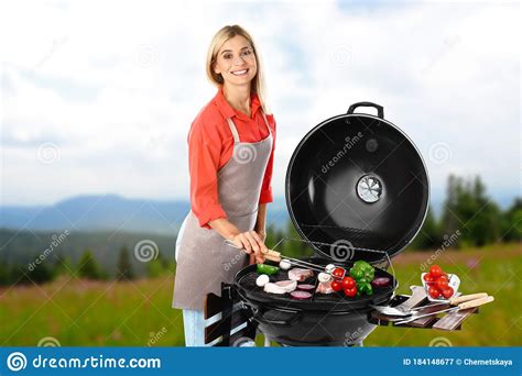 Woman In Apron Cooking On Barbecue Grill Picnic Time Stock Image