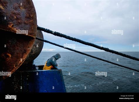 Fisherman Works Winch For The Dragger Net On Fishing Trawler