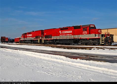 A Red Train Traveling Down Tracks Next To Snow Covered Ground