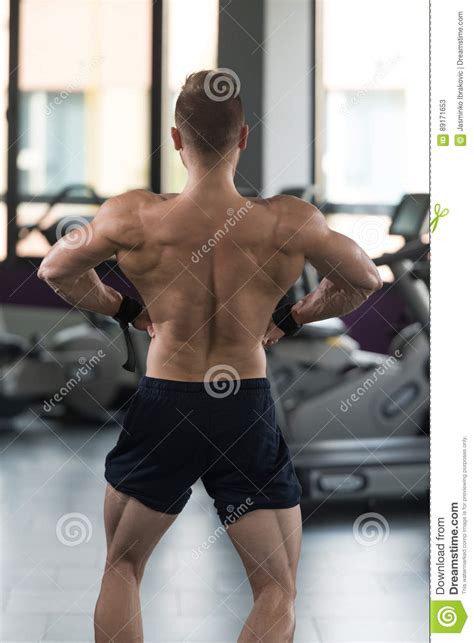 Muscular Man Flexing Back Muscles In Gym Stock Image