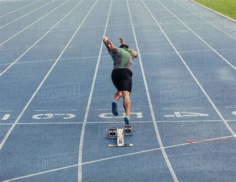 Rear View Of An Athlete Starting His Sprint On An All Weather Running