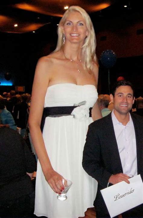 A Woman In A White Dress Standing Next To A Man
