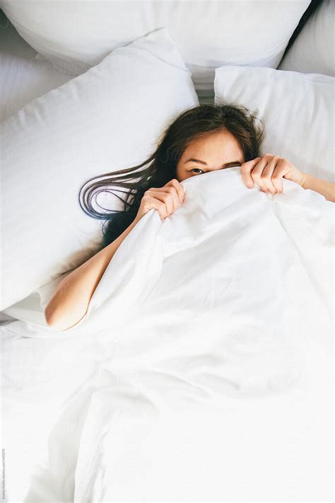 Young Woman Hiding Under Blanket In Bed By Stocksy Contributor Andrey Pavlov Stocksy