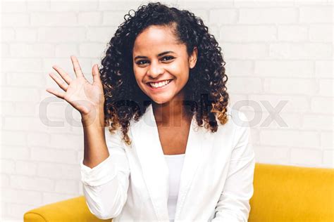 beautiful african american black woman smiling at camera waving and saying hello to you stock