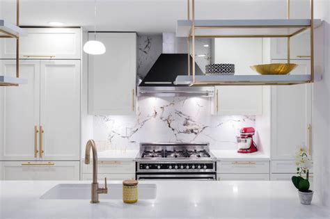 Prime kitchen cabinets offers custom kitchen design in vancouver. A kitchen with white shaker cabinets and Gold / Brass ...