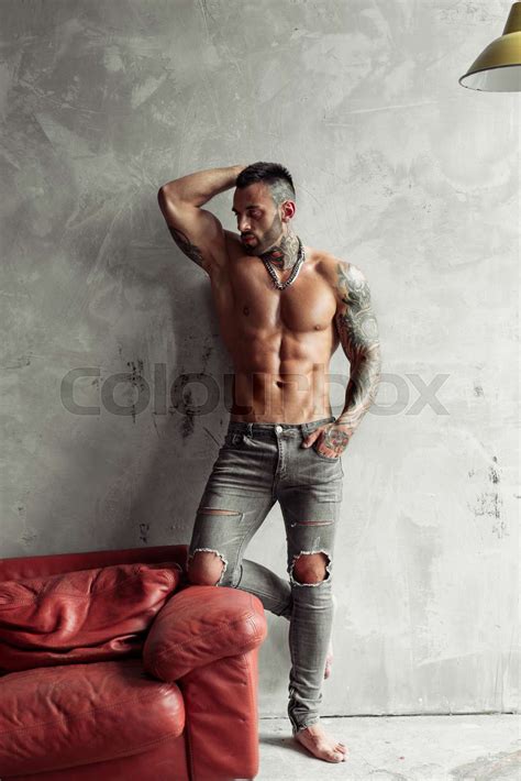 Fashion Portrait Of Sexy Naked Male Model With Tattoo And A Black Beard Standing In Hot Pose On