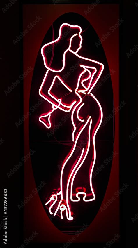 neon sign full size naked woman in heels showing entrance to night strip dance club bar in red