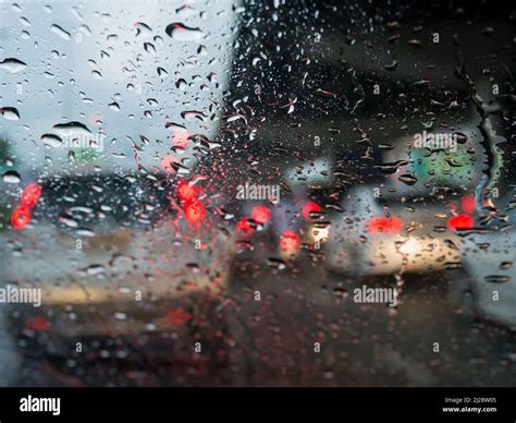 Traffic In Rainy Day With Road View Through Car Window With Rain Drops