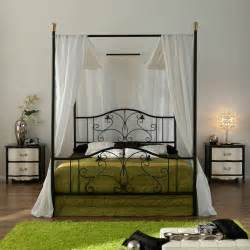 Simply hang sheer drapery panels on wire rope threaded through eye hooks in the ceiling and accent with strings of cascading holiday lights. Elegant Iron Canopy Bed Frame - HomesFeed