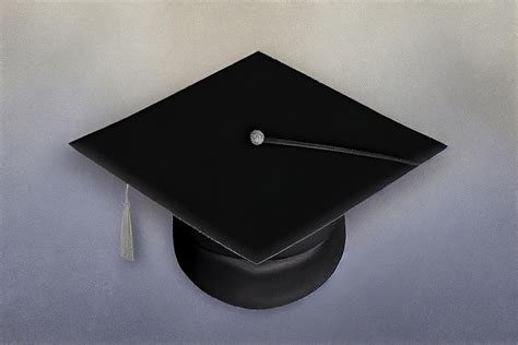 Черная академическая кепка или выпускная шляпа на студенческом столе