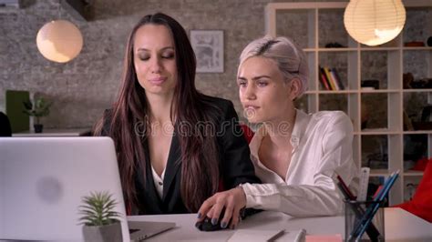 Two Young Pretty Lesbians Working In Modern Office Woman Flirting With