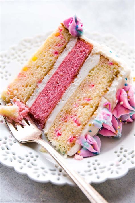 A Slice Of Cake On A White Plate With A Fork Next To It And Sprinkles