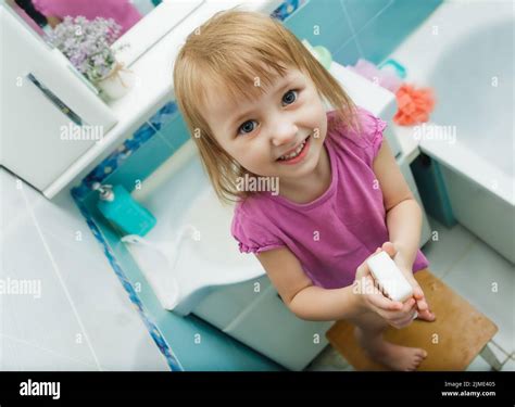 Smiling Little Girl Holding Soap In The Bathroom Stock Photo Alamy