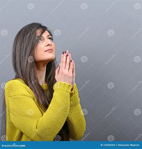 Woman Praying About Something Or Begging For Mercy Against Gray