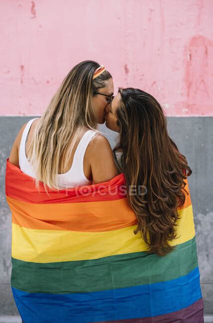 couple lesbian woman with gay pride flag on the street of madrid city — people blonde stock