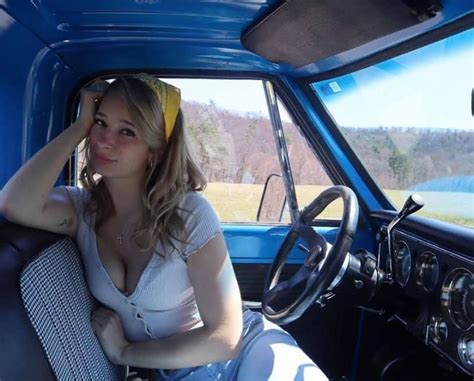 A Woman Sitting In The Driver S Seat Of A Blue Truck With Her Hand On