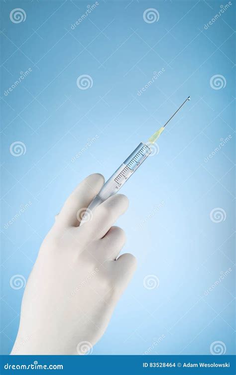 Doctors Hand Holding A Syringe On Blue Background Stock Photo Image
