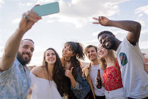 Multiracial Group Of People Taking A Selfie Outdoors By Stocksy
