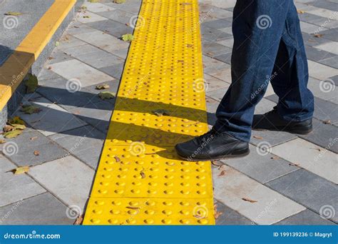 Man Walking On Yellow Blocks Of Tactile Paving For Blind Handicap