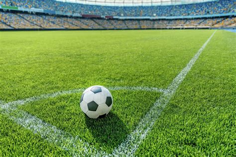 Soccer ball on grass in corner kick position on soccer field stadium ...