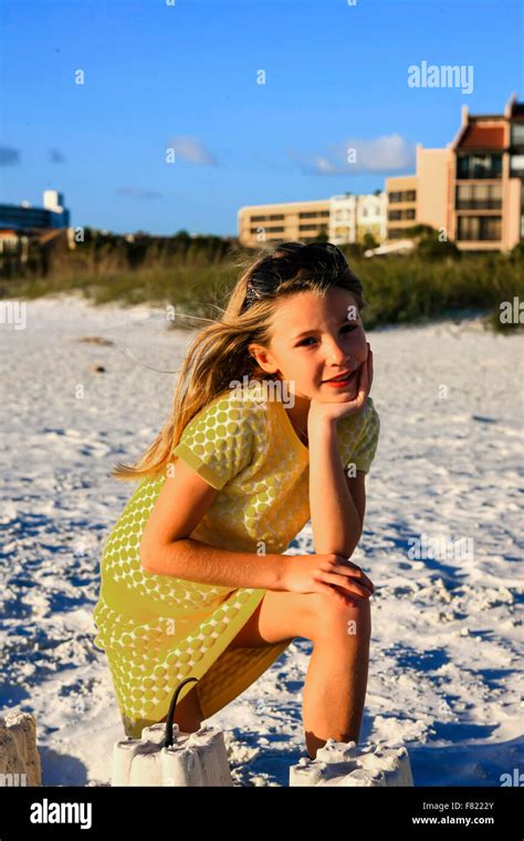 Young Girl Posing At Sunset By The Sand Castle She Built