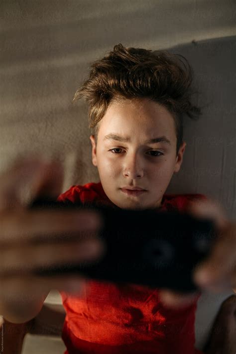 Boy Holding Mobile Phone By Dejan Ristovski