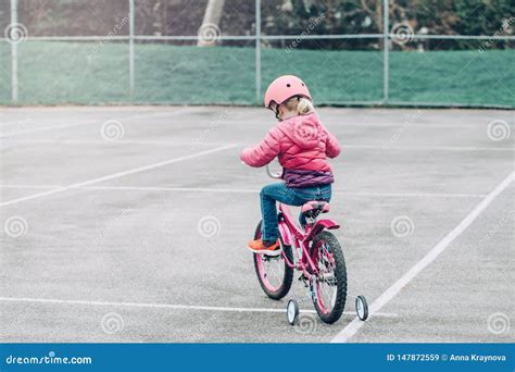 Preschooler Girl Riding Pink Bike Bicycle In Helmet On Backyard Road