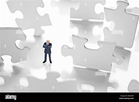 Businessman Figurine Surrounded By Puzzle Pieces Stock Photo Alamy