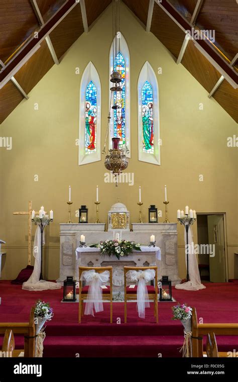 Wedding Flowers With Candles Set Up On The Altar In Catholic Church