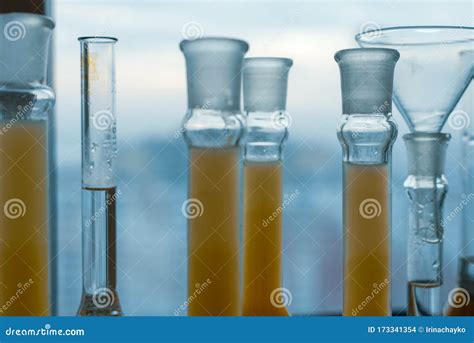 Closeup A Long Row Of Glass Flasks With A Yellow Solution On A